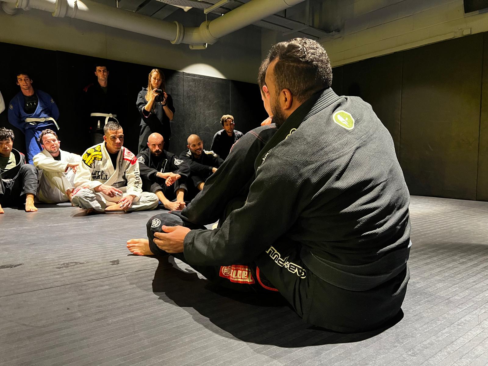 Coach Max Lima talking to the class on the mats